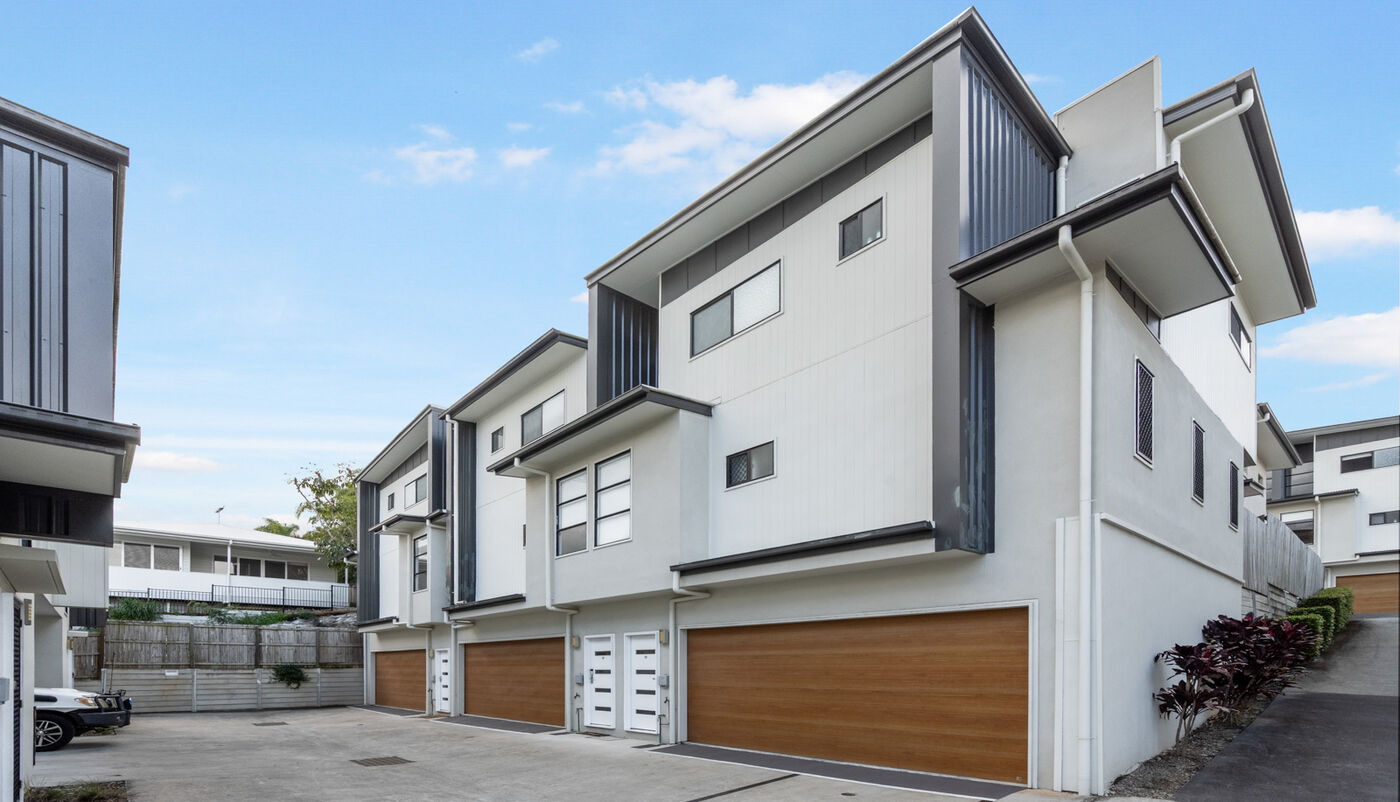Exterior of the townhouse complex with timber garage doors